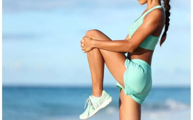 Wanita melakukan peregangan lembut di pagi hari dengan sinar matahari